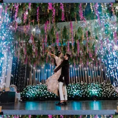 A stunning wide shot of the couple's first dance at their Sangeet, surrounded by cold pyro and beautiful floral decor.