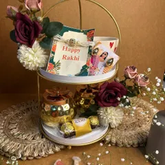 A royal treat for your bhaiya and bhabhi. This two-tiered stand is filled with personalized items, Ferrero Rocher chocolates, and a beautiful Rakhi set to make them feel cherished.