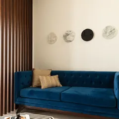 We are never afraid to use a dash of bold color. This plush blue velvet sofa creates a stunning focal point in the living room, complemented by the geometric rug and mother-of-pearl inlay table.