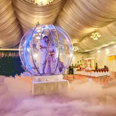A still shot of the Crystal Ball entry, showing how the couple is encased in the illuminated sphere amidst a sea of low fog. This rental is perfect for indoor banquet halls and creates a magical atmosphere.