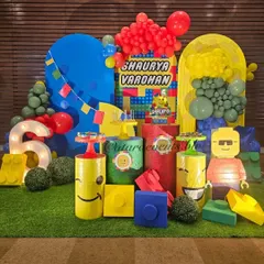 The main stage for this LEGO party is a builder's paradise, with a light-up number "6", large custom-built LEGO figures, and colorful block props on a grass-like floor.