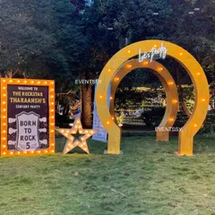 The entrance to the "Rockstar Tharaansh's Concert Party," featuring a lit-up welcome sign, a star-shaped marquee light, and a custom archway. This setup immediately establishes the high-energy concert theme.