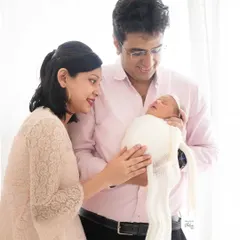 A candid moment of parents admiring their newborn. I guide families into natural poses that feel comfortable and result in genuine, emotional photographs.