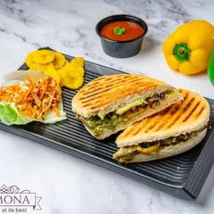 A freshly prepared Exotic Grilled Veggie Sandwich in panini bread. I use a medley of colorful vegetables like zucchini and bell peppers, grilled to perfection and served with a side of salad and chips.