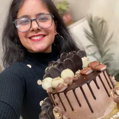 Here I am with one of my favorite creations, a custom chocolate drip cake for a book lover. It’s loaded with different kinds of chocolate decorations and a touch of gold to make it feel extra special.