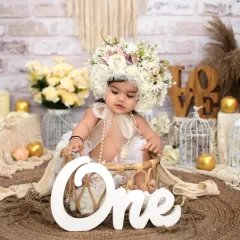 A bohemian dream for her first birthday. This beautiful setup features a stunning floral headpiece, a rustic jute rug, and soft, neutral tones to create an artistic and timeless milestone portrait.