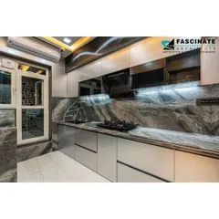 A sleek and functional modular kitchen we designed for a residence in Seawoods. The space features high-gloss grey cabinets, a dramatic marble-patterned backsplash, and integrated under-cabinet lighting for a bright, efficient workspace. Every element is chosen for its durability and timeless aesthetic.