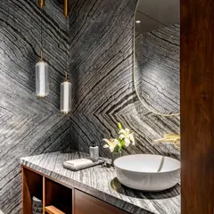 Materiality is at the core of our practice. In this powder room for the Parishram residence, we used book-matched slabs of dramatic, locally sourced granite to create a powerful visual statement, turning a functional space into a work of art.