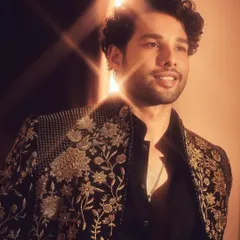 A candid, smiling shot of Siddhant. The light catches the metallic thread in the embroidery, showing how the look comes alive with movement.