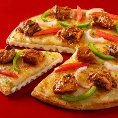 A chicken tikka pizza from Ovenstory, shot on a bold red background. This high-quality image is designed to look delicious on delivery apps and marketing materials.