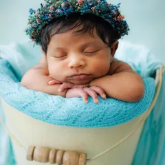 This is the heart of my newborn photography. A peacefully sleeping baby, posed safely and comfortably in a classic bucket prop, crowned with a delicate floral headband. These are the serene, timeless portraits I cherish creating.