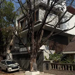 A view of a modern home from the street, designed to integrate with the existing trees and landscape, showcasing a balance between privacy and openness.