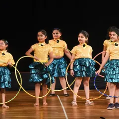 Our young hoop troupe posing proudly on stage at Kamani Auditorium. Our classes give kids the chance to build confidence through performance.