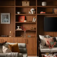 To maximize seating and storage in this compact living room, I designed a custom TV unit that spans the entire wall. It includes a built-in seating nook, drawers for media accessories, and open shelves for books and collectibles.