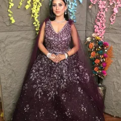 Make heads turn at your reception or cocktail party with this deep purple sequined gown. The intricate silver sparkle work catches the light beautifully, and the attached cape adds a touch of modern drama. It’s a glamorous look available for rent for your special night.