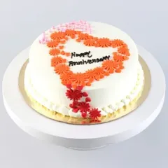 Wish your partner a "Happy Anniversary" with this elegantly designed cake. It features a beautiful heart made of delicate orange sugar flowers, making your milestone celebration even sweeter.