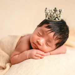 This is my classic posed newborn portrait style. I focus on the peaceful, sleepy expressions and tiny details of your baby, using soft textures and simple props like this delicate crown to create timeless, frame-worthy art.
