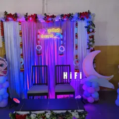 A simple and elegant seating arrangement for a traditional baby shower ceremony at home, complete with a custom neon sign in Marathi.