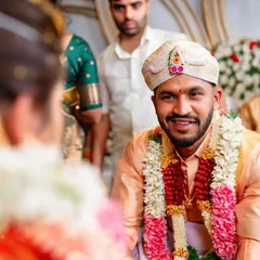 An over the shoulder shot of the groom looking at his bride with a smile during the muhurtham. This perspective creates a personal and intimate feel.