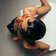 An unconventional overhead angle from a Calvin Klein shoot. This perspective creates a graphic composition, focusing on the model's pose, styled hair, and accessories.