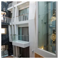 The Cleft House was designed as a breached monolith, with internal balconies and glazed voids that create visual connections across the home. This view from an upper level looks down into the central atrium, highlighting the verticality and layered nature of the space.