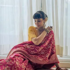 A quiet moment in the stunning, year-long-crafted Banarasi bandhani saree, showing its rich color and texture.
