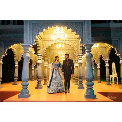 A grand pre-wedding shoot with stunning architectural elements. The elegant setting and chandelier lighting add a touch of royal splendor to this couple's portrait.