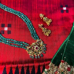 A masterpiece jewellery set designed by me, featuring a stunning green beaded necklace with a traditional pendant. It pairs perfectly with this rich red dupion silk saree.