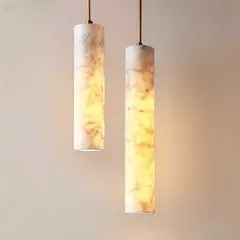 A pair of cylindrical pendant lights carved from marble. When lit, the natural veins of the stone become visible, making each light a unique piece of art.