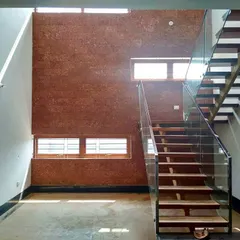 Natural light is a key material in my designs. This double-height courtyard uses a large skylight to illuminate the space, highlighting the rich texture of the laterite stone wall and the clean lines of the modern floating staircase.