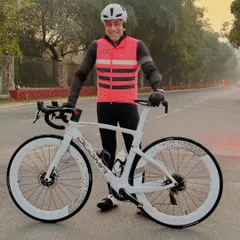 A rider proudly displaying his white Pinarello Dogma, a top-of-the-line racing bike.