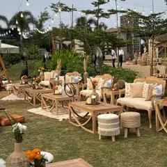 A beautiful lounge area with wooden furniture, macrame-detailed stools, and neutral-toned upholstery, perfect for a relaxed conversation.