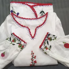 We added a custom red crochet lace trim to the neckline and cuffs of this beautiful embroidered white top. It's a great way to add a pop of color and a handmade detail.
