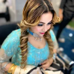 This glamorous party look features structured curls and balayage highlights. The hairstyle is designed to complement the client's makeup and outfit perfectly.