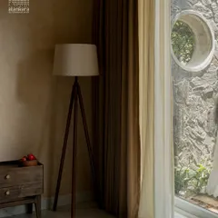 This image captures a serene corner where my custom curtains play a key role. The layered effect of a heavy brown curtain over a delicate sheer allows for versatile light management while adding warmth and texture to the room.