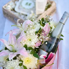 A close-up of the proposal details. We arranged a bottle of sparkling wine within a beautiful bouquet of lilies and chrysanthemums, ready for the couple to celebrate their special moment.