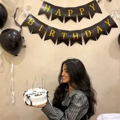 A happy client with her classic vintage cake, decorated with simple black bows. It's a chic and timeless design that's perfect for any stylish celebration.