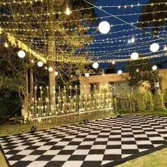We transform outdoor spaces into magical party zones. This custom black-and-white checkered dance floor, set under a canopy of string lights and paper lanterns, created an inviting and high-energy atmosphere for a Sangeet night.