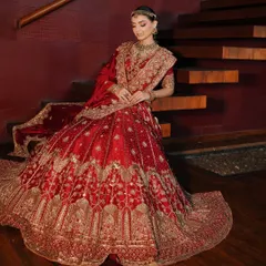 The classic red bridal lehenga is iconic, and my goal is to make it uniquely yours. Here, I focused on creating a regal silhouette, draping the rich fabric to highlight the exquisite gold embroidery. The look is completed with layered traditional jewelry, crafting a portrait of a timeless, royal bride.