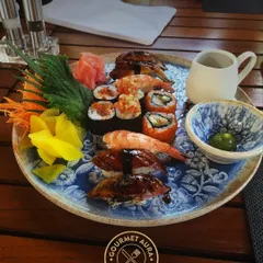 A beautiful platter of assorted sushi and nigiri, featuring shrimp, unagi, and spicy tuna rolls. Served on a traditional blue and white ceramic plate, it's a feast for the eyes and the palate.
