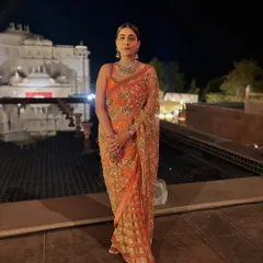 The full look of my Sabyasachi saree against a beautiful palace backdrop at night. The intricate embroidery and color truly shine in this setting.