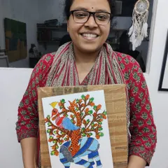 A participant beams with pride, holding her completed Gond art piece. This workshop dives into the unique patterns and storytelling of this beautiful Indian folk art.