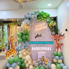 A soft and sweet jungle theme for Veer's birthday. This setup uses a pastel color palette of green, blue, and white, with cute giraffe and deer cutouts.