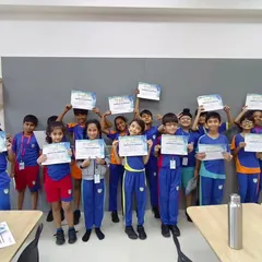 Mission accomplished! Students proudly hold up their certificates of completion after a successful series of STEM workshops at their school.
