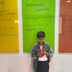 Using a mobile phone as a prompt, this student prepares for an impromptu talk. This exercise is excellent for developing the ability to quickly organize thoughts and speak coherently without a script.