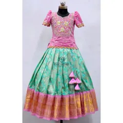 An elegant pattu pavadai with a pink peplum top and a sea-green Banarasi skirt. The top features beautiful gold and pink maggam work.