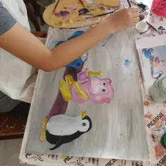 Our oil painting classes are perfect for kids who love to bring their favorite characters to life. Here, a young student carefully paints a colorful cartoon scene, learning about blending and composition.