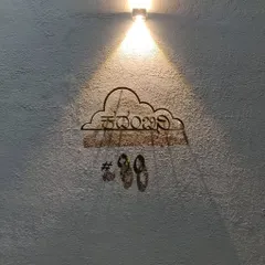 At night, the custom nameplate is highlighted by a single spotlight, casting beautiful shadows and emphasizing the texture of the compound wall.