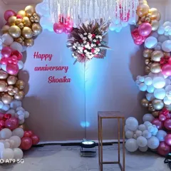 A festive anniversary backdrop for "Shoaika." I designed a balloon arch in shades of pink, gold, and white, with a floral centerpiece and hanging crystals.