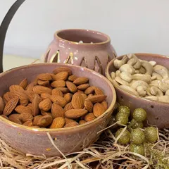 The hamper includes two bowls for serving dry fruits and a beautiful perforated tealight holder that casts lovely shadows when lit.
